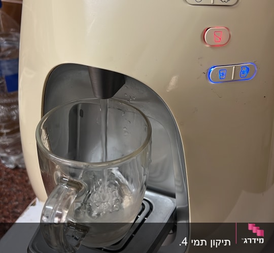 מכונת מים עם כוס זכוכית מתמלאת במים